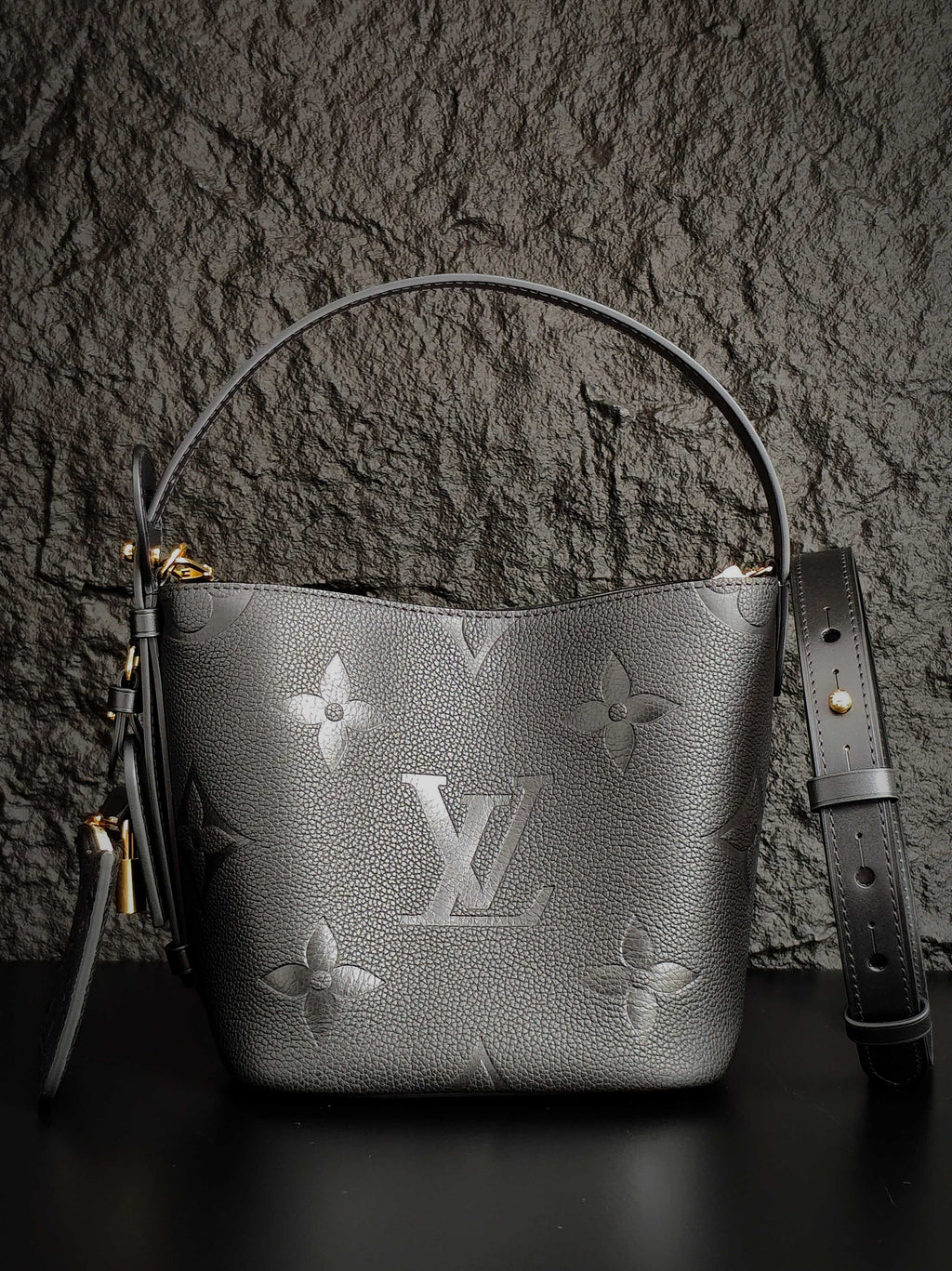Louis Vuitton monogram bucket bag in gray with top handle and shoulder strap