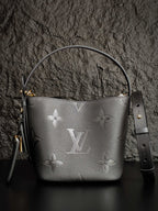 Louis Vuitton monogram bucket bag in gray with top handle and shoulder strap