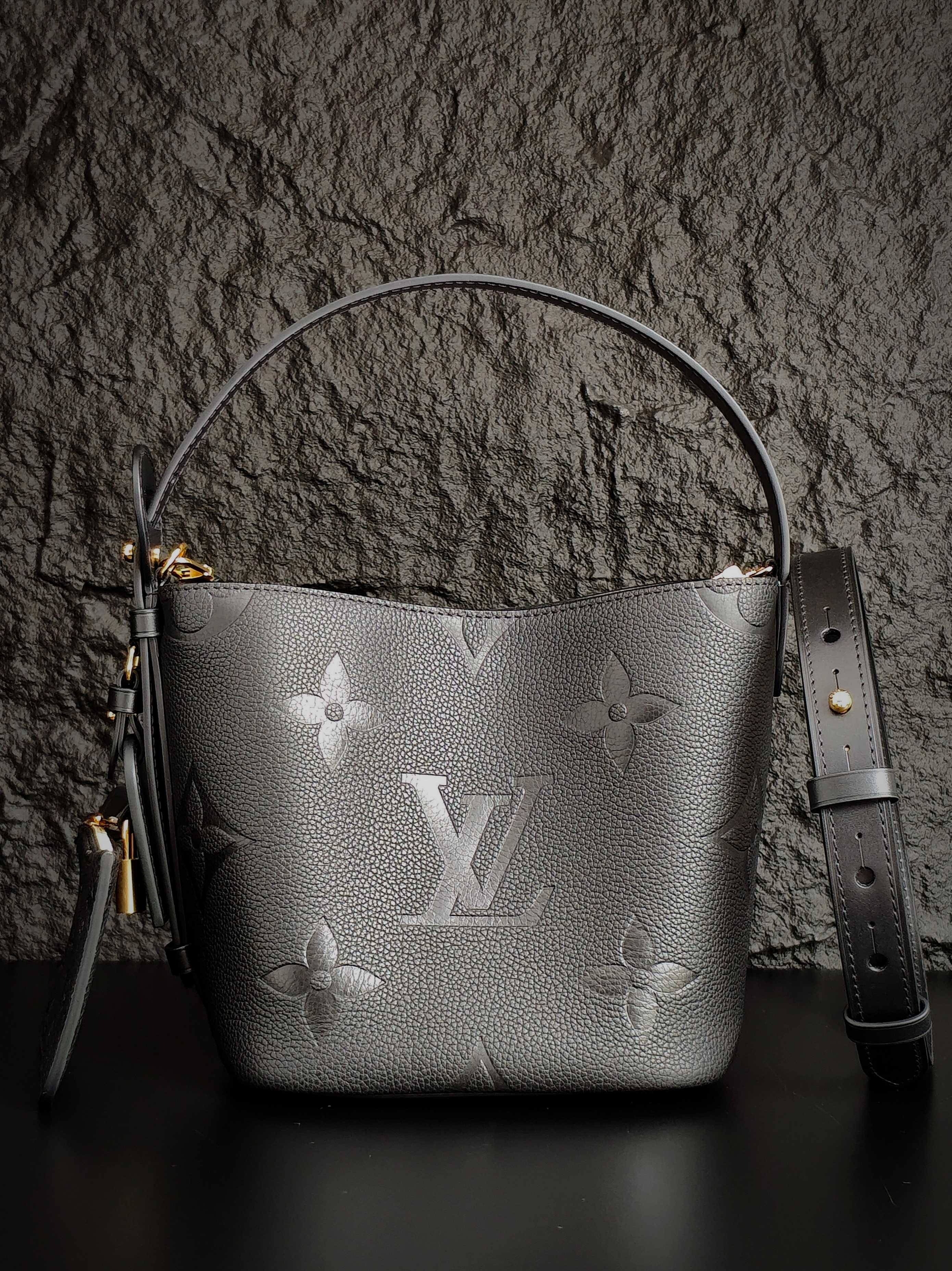 Louis Vuitton monogram bucket bag in gray with top handle and shoulder strap