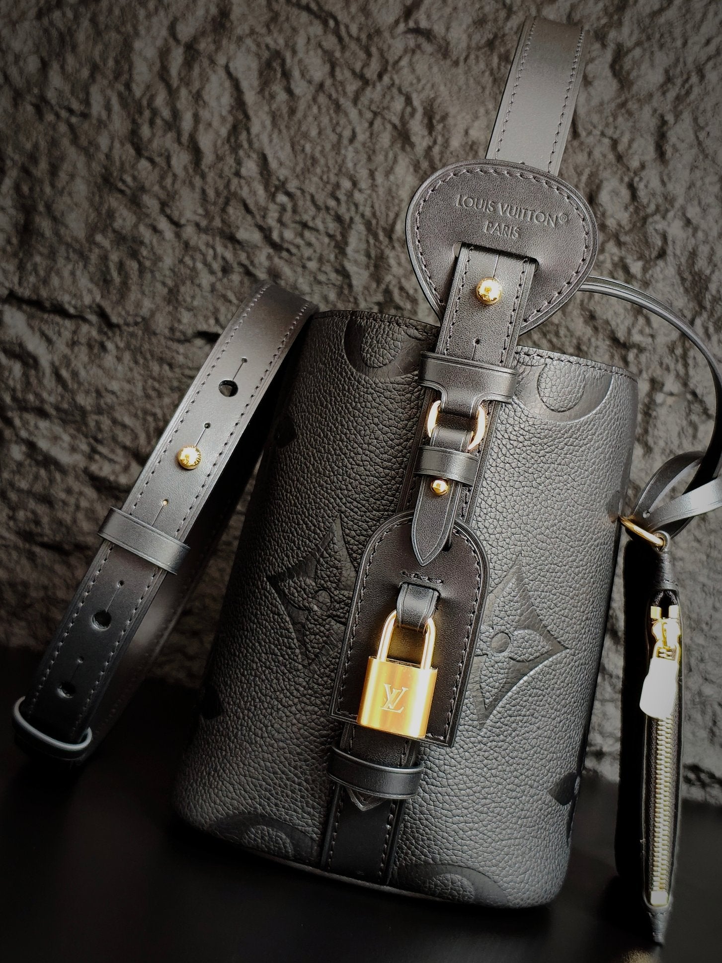 Louis Vuitton monogram bucket bag in gray with front lock charm and shoulder straps