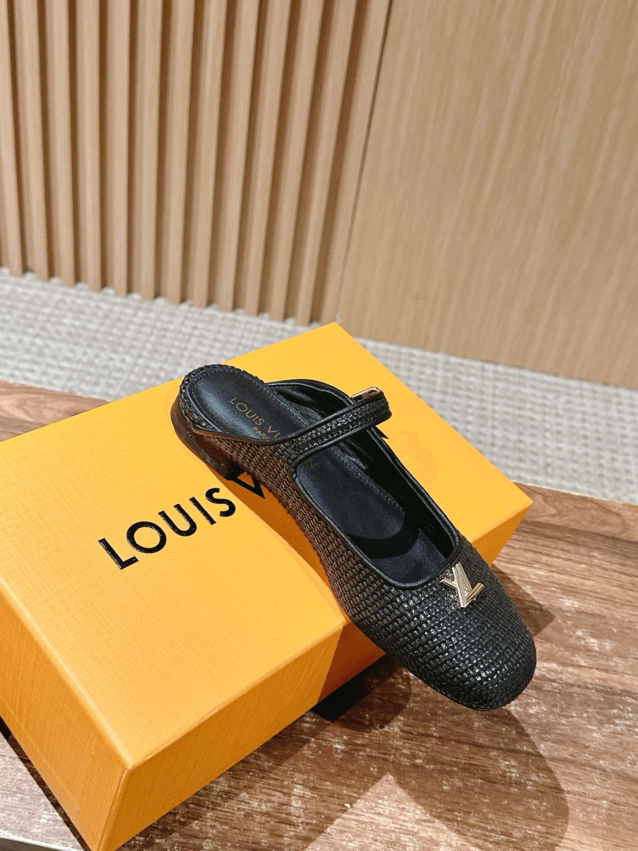 Louis Vuitton unisex black textured flats with strap and gold emblem, side profile