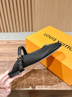 Louis Vuitton unisex black textured flats with gold buckle, held by hand