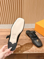 Louis Vuitton unisex black textured flats with light sole, hand holding back shoe