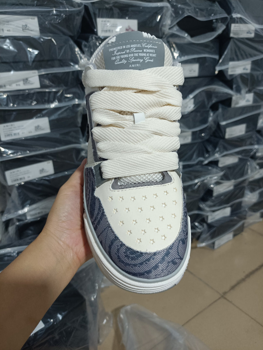 Amiri low-top sneaker tongue and laces, cream and navy patterned panels, white sole