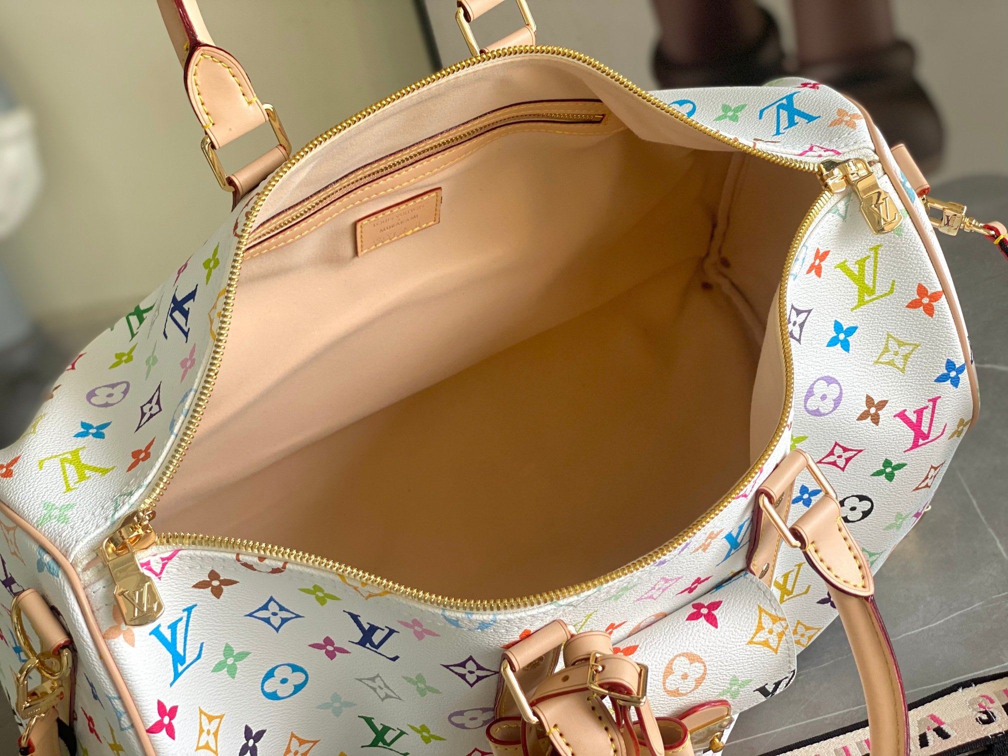 Louis Vuitton handbag open view with beige interior lining and multicolor monogram exterior