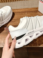 White Moncler athletic sneaker with chunky sole, side gore panel, and lace-up upper.