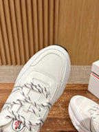 White Moncler sneaker toe with lace-up paneling and side logo embroidery detail.