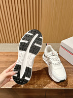 Moncler sneaker outsole with tread pattern and white upper with lace-up details.
