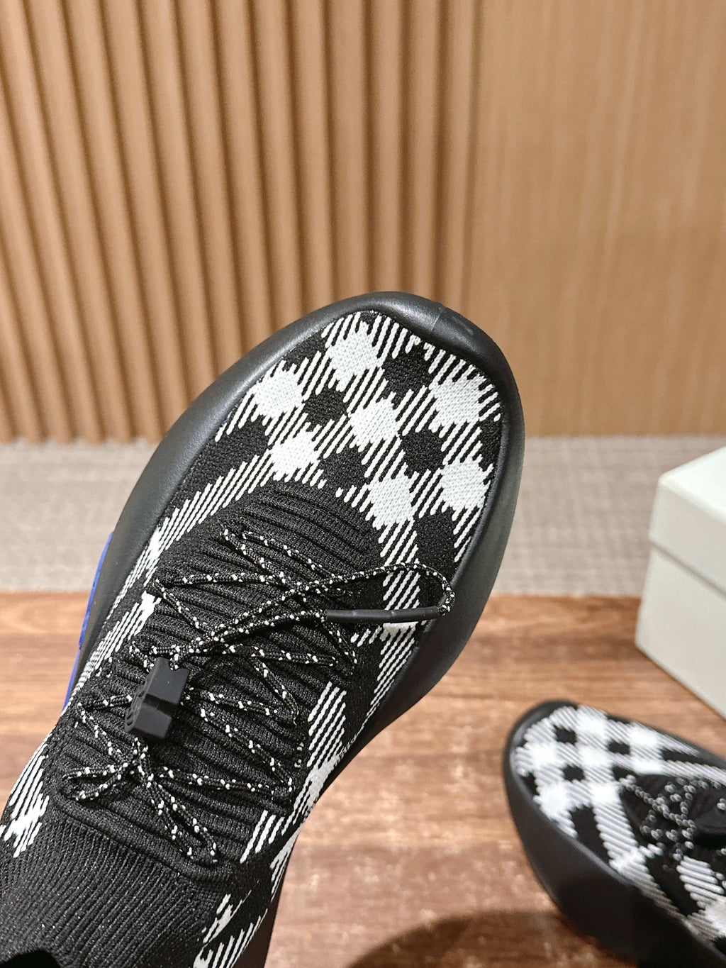 Close-up toe of black and white check knit sneaker with black laces