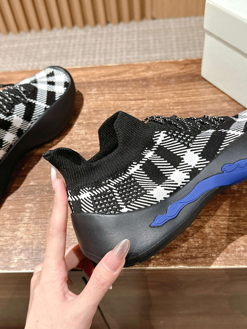 Black knit sneakers with white check pattern, lace-up details, blue sole