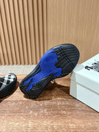 Outsole of black and blue knit sneaker with textured tread pattern