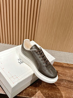 Low-top sneaker on box, dark taupe leather, brown lace-up and white rubber sole
