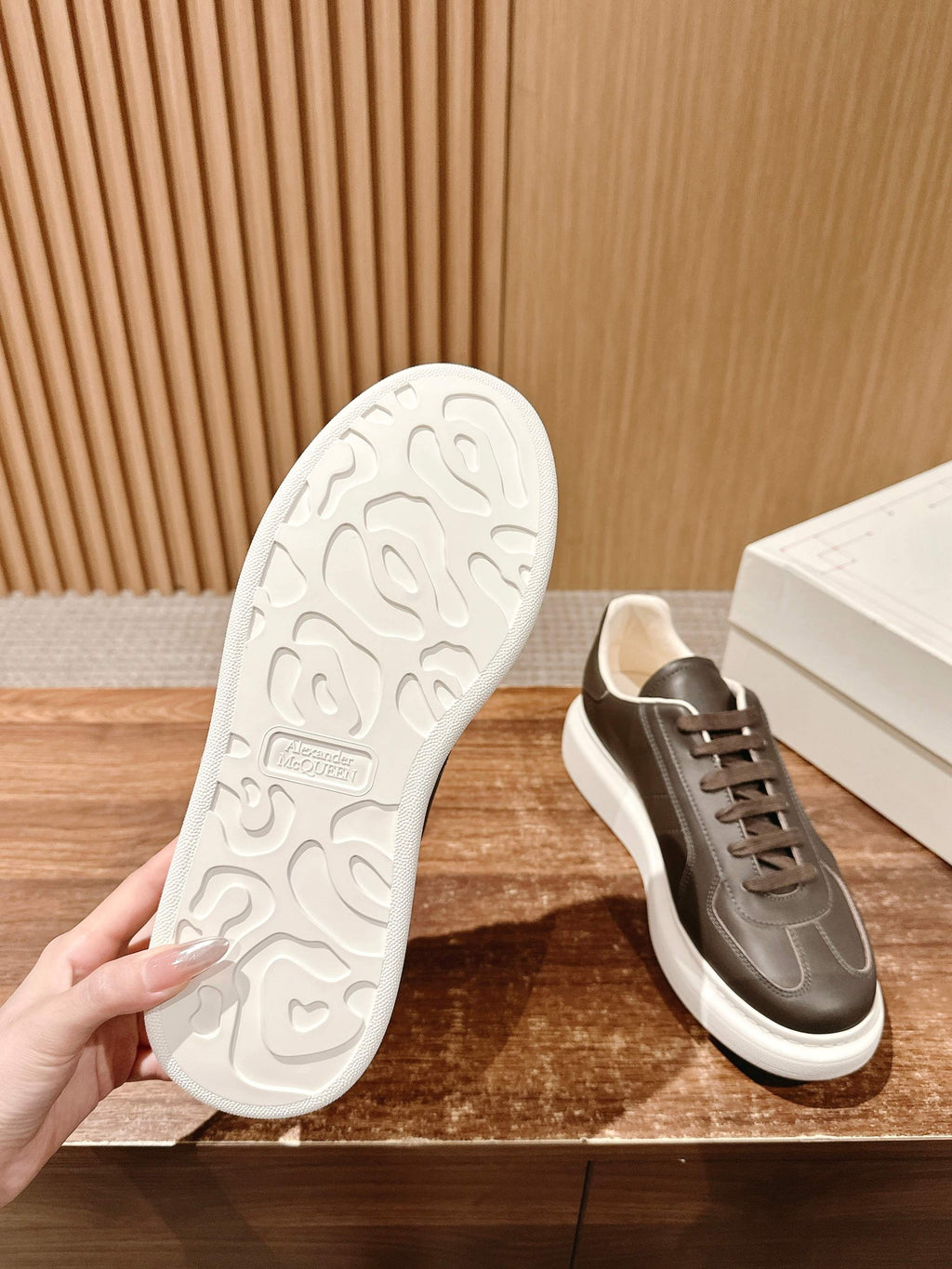 Sneaker outsole and side view, dark taupe leather upper with white rubber tread sole