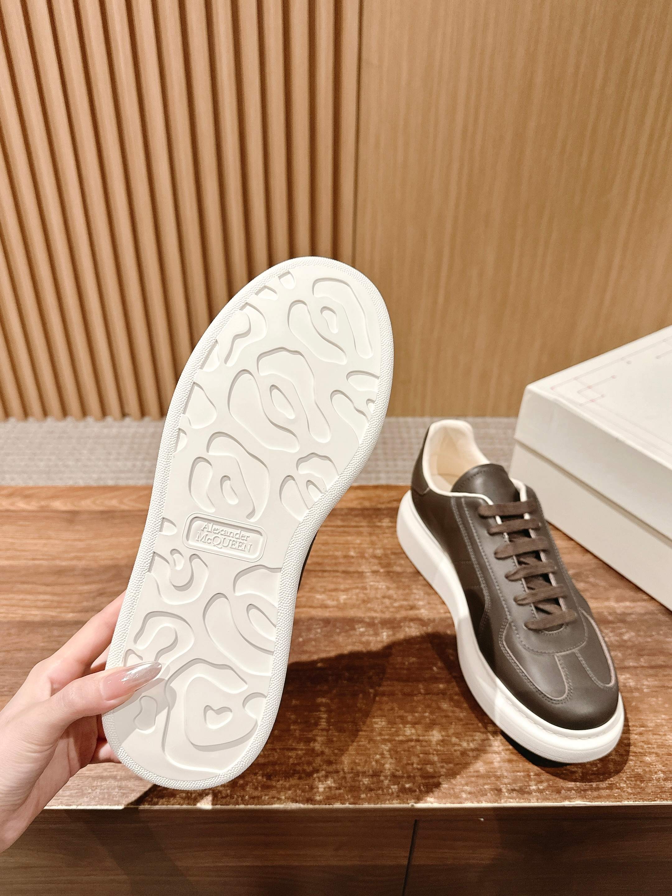 Sneaker outsole and side view, dark taupe leather upper with white rubber tread sole