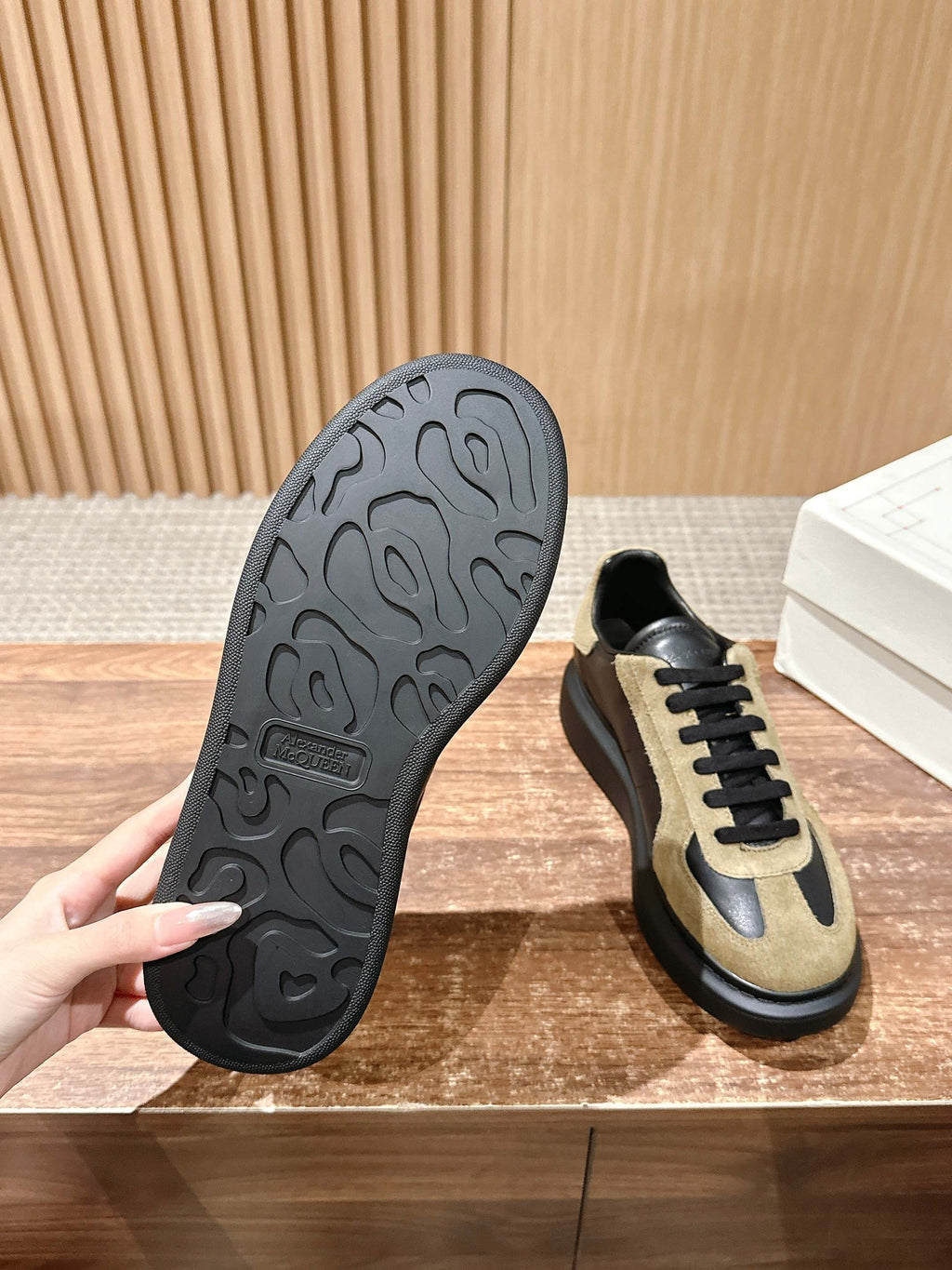 Alexander McQueen sneakers outsole view, black tread and tan-and-black upper