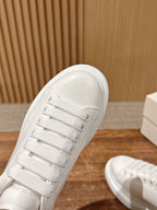 Alexander McQueen white sneaker side profile with lace eyelets and stitched panels