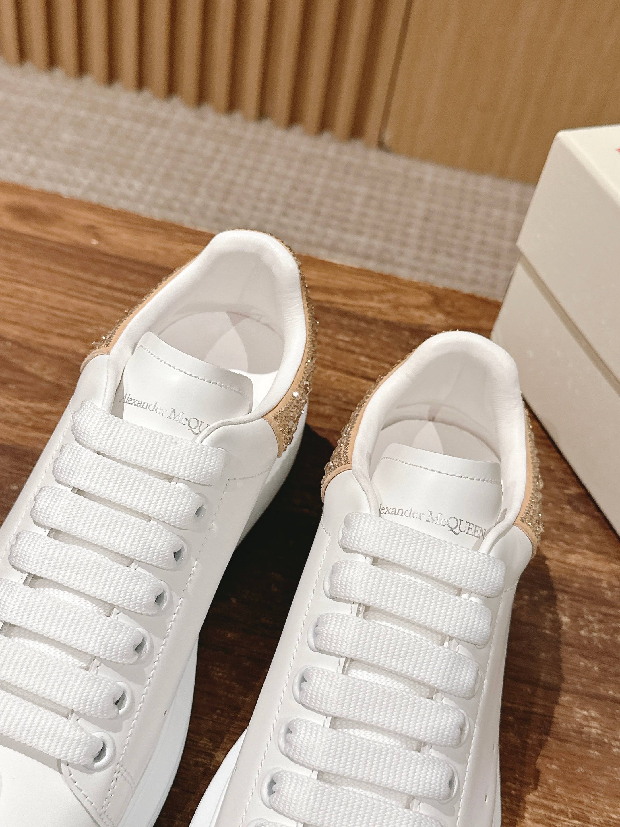 Alexander McQueen white leather sneakers with gold glitter trim, side-by-side view