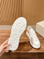 Alexander McQueen white sneakers with textured rubber outsole, side and sole view
