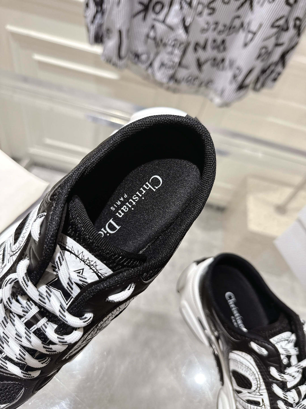 Close-up of Dior black lace-up sneaker side with white graphic panels