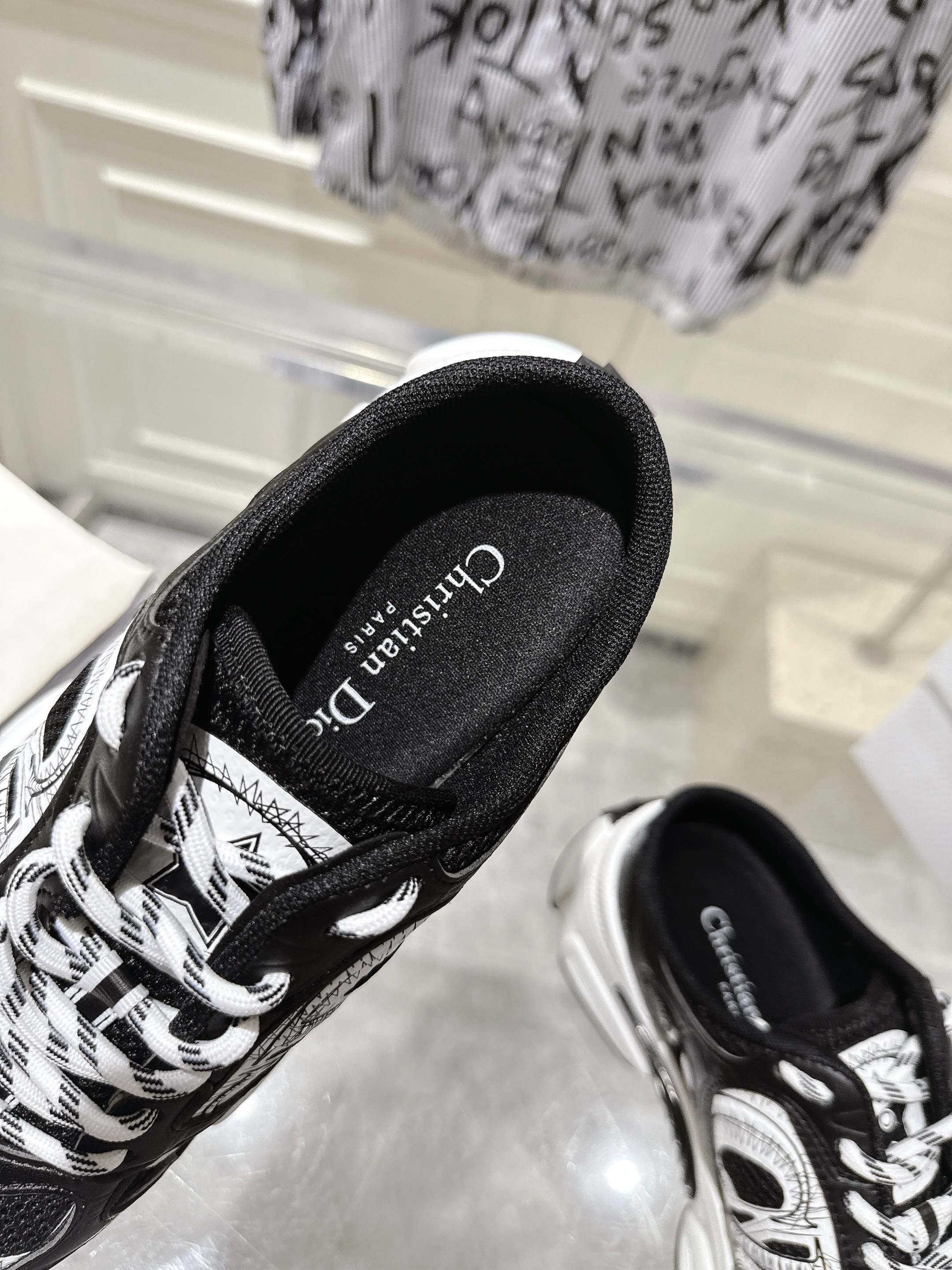 Close-up of Dior black lace-up sneaker side with white graphic panels