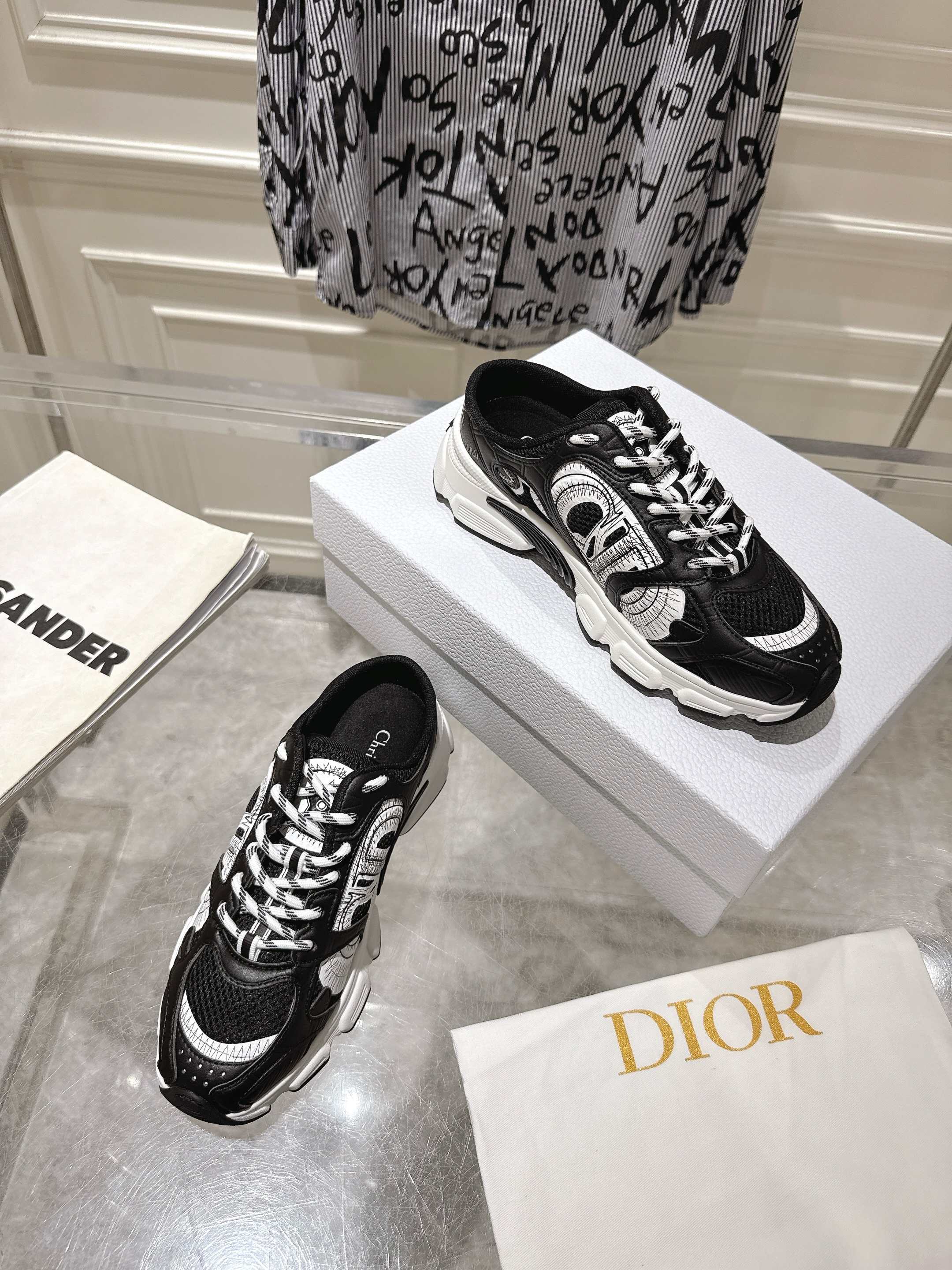 Dior black lace-up sneakers with white highlights on a white shoe box