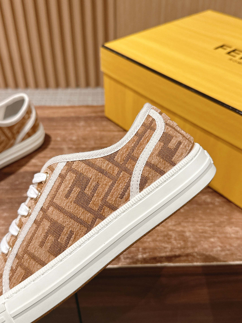 Fendi unisex sneaker close-up, brown monogram side stripe and white sidewall