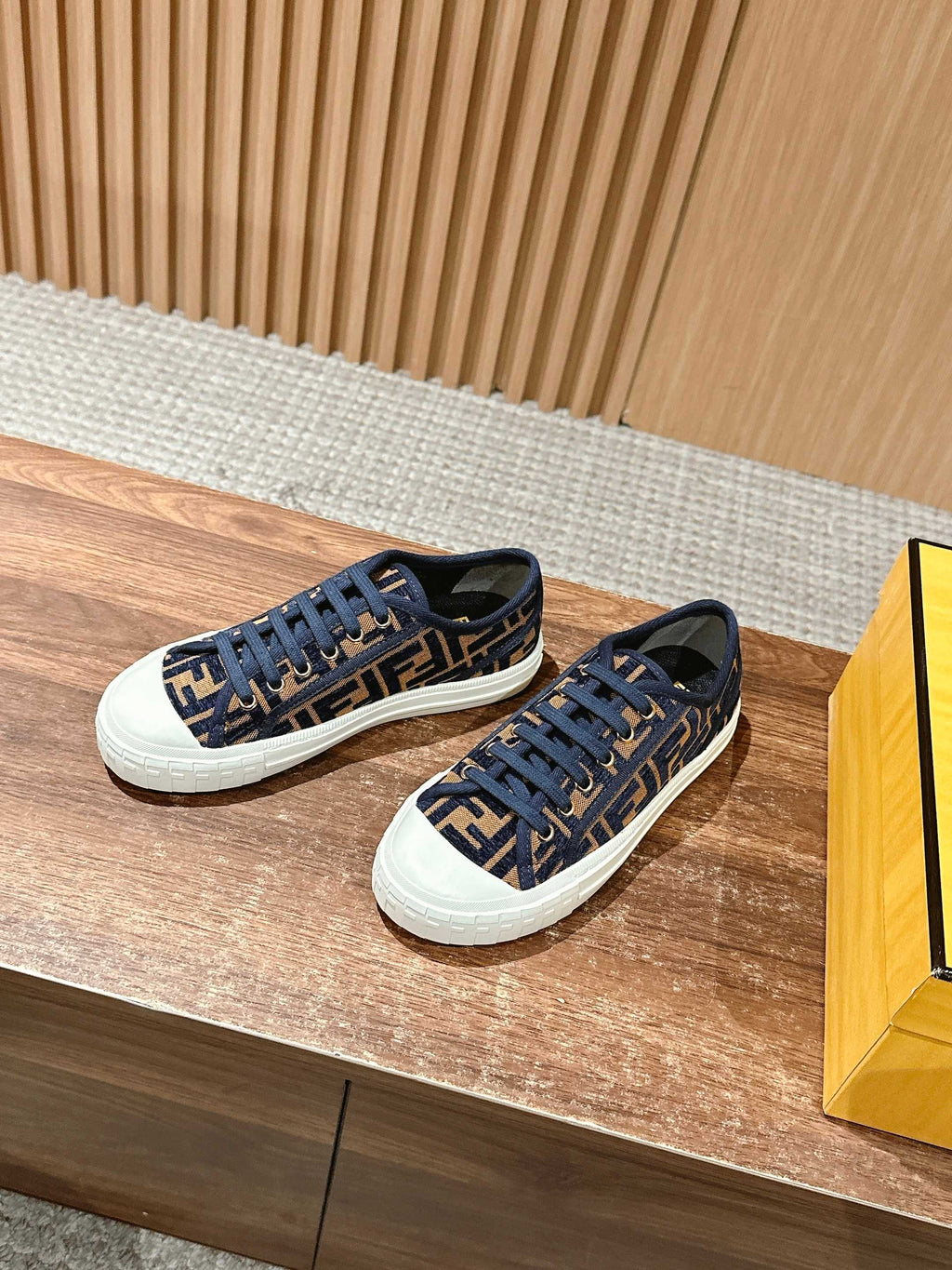 Pair of navy FF monogram sneakers with blue lace-up front and white rubber soles