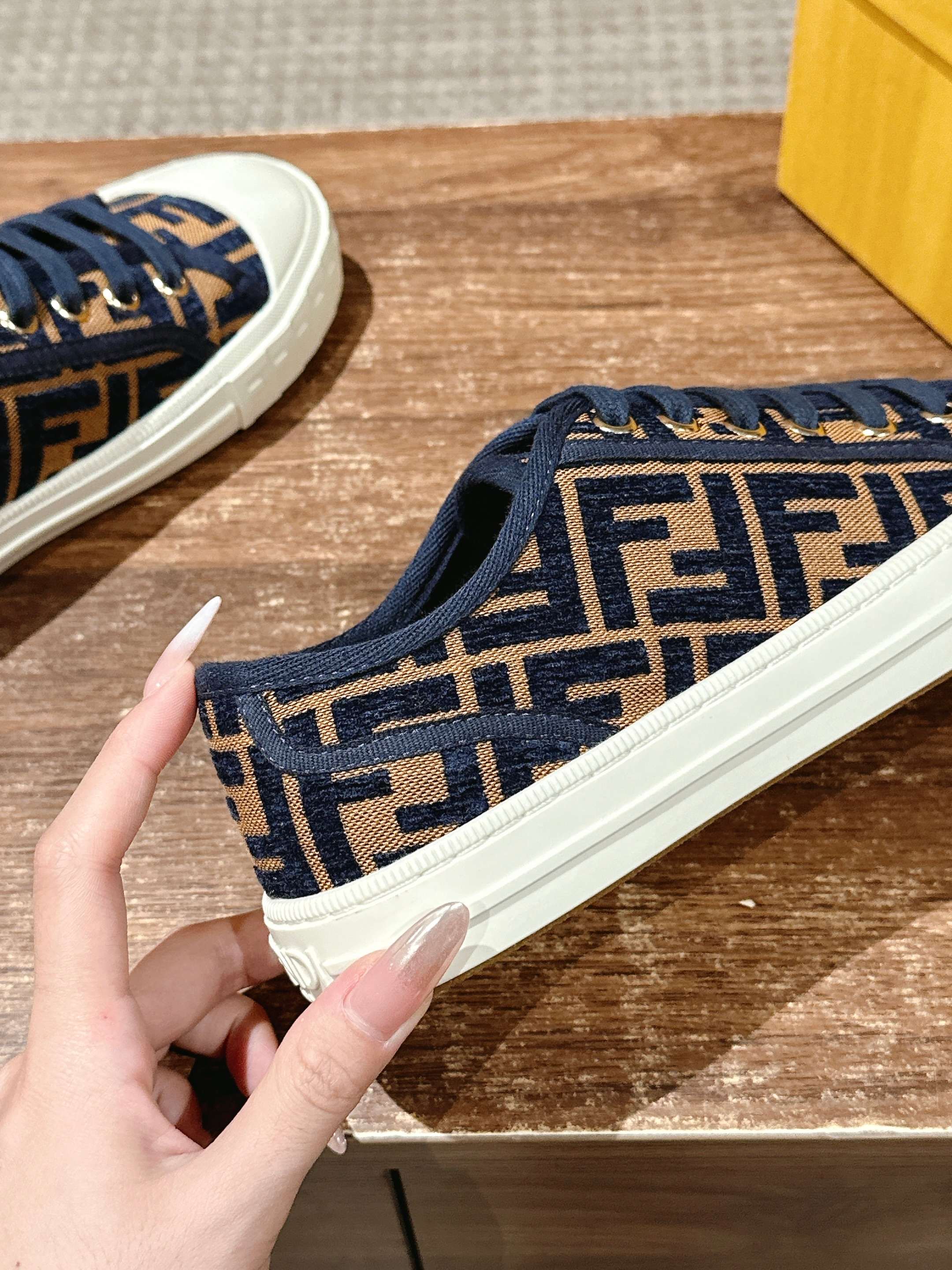 Close-up of navy FF monogram sneaker with blue laces and white rubber sole