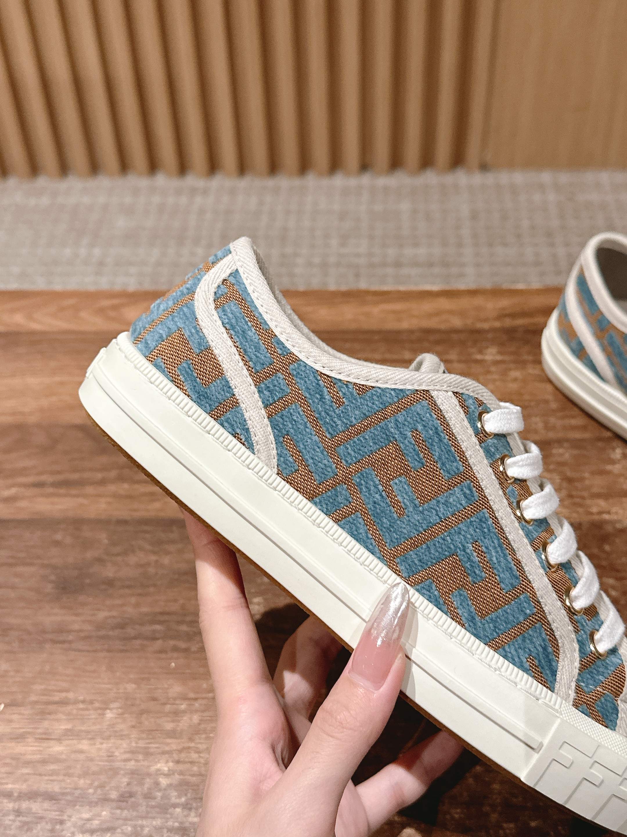 Fendi low-top sneakers in hand, blue logo print with white laces and sole