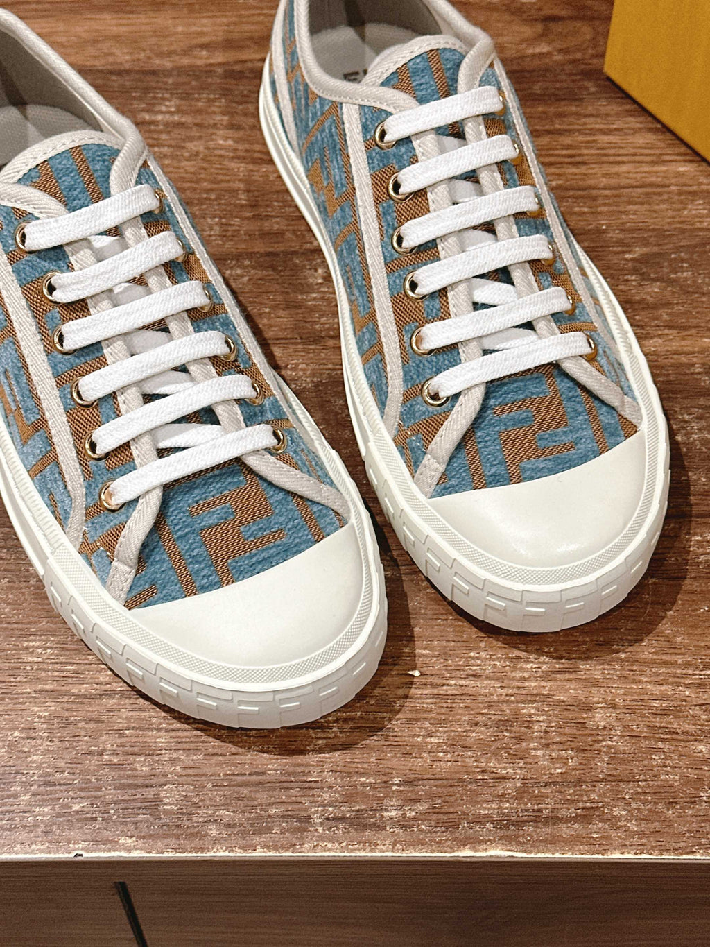 Fendi sneakers close-up, blue monogram upper with white laces and rubber toe cap