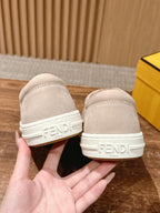 Beige suede sneakers with white heel stripe and embossed logo, back view, unisex.