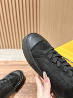 Fendi unisex black lace-up sneaker close-up, hand holding front