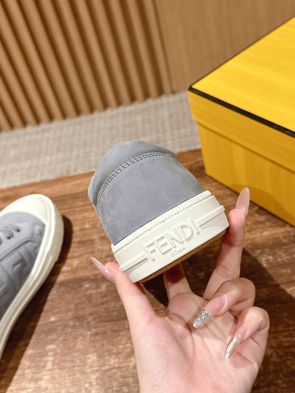 Gray sneaker profile with white sidewall and embossed FENDI logo on strap