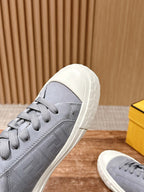 Gray low-top sneakers in angled view with grippy white sole tread