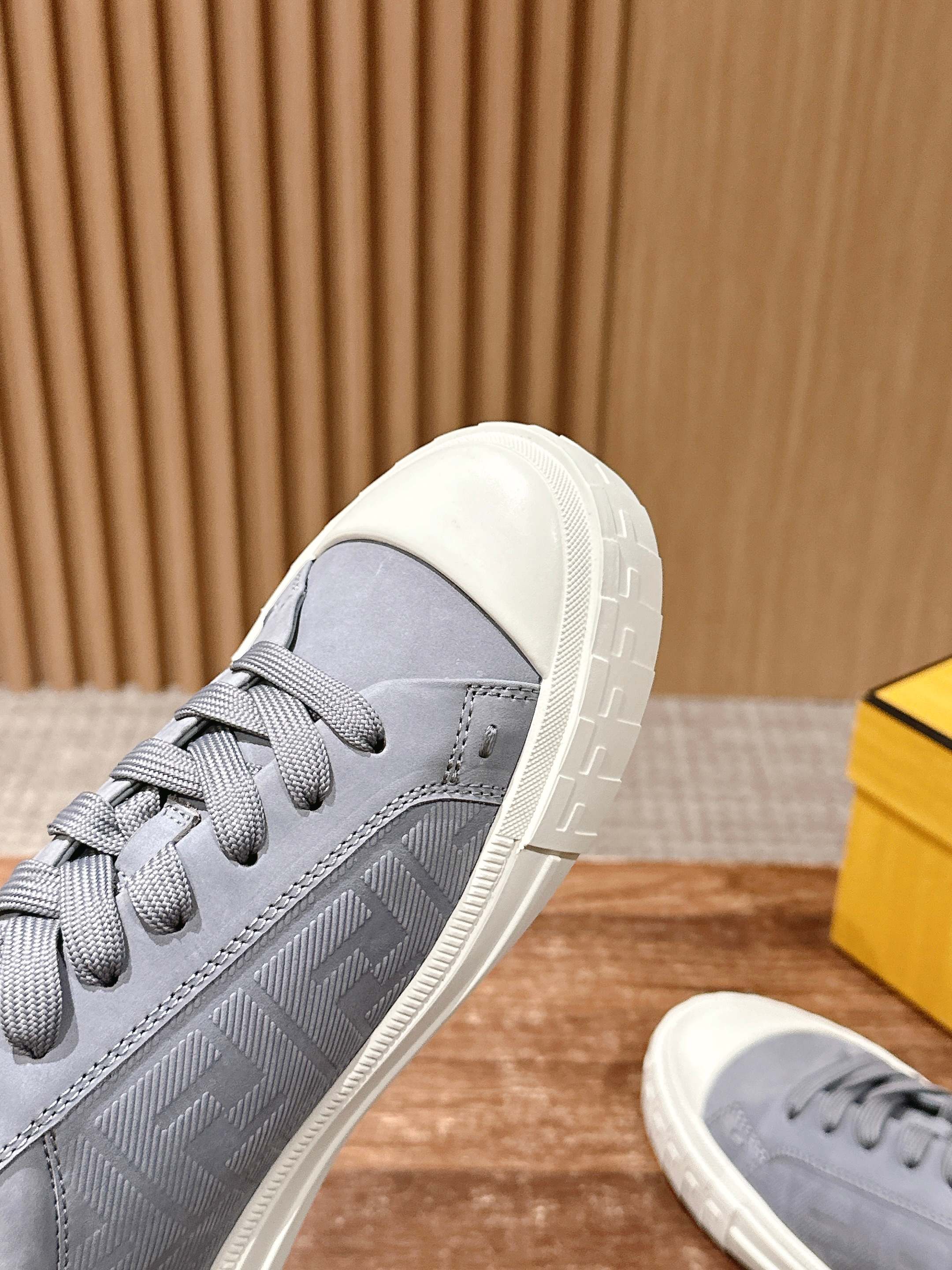 Gray low-top sneakers in angled view with grippy white sole tread