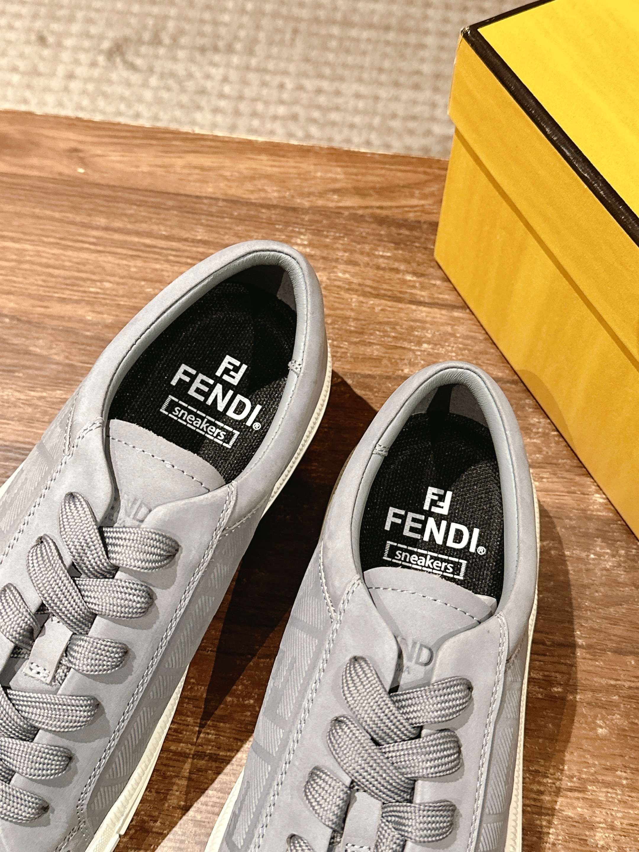 Gray FENDI sneakers close-up of tongue and lining with printed brand logo