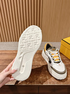 Fendi sneaker outsole view with textured tread and white upper with orange lace details
