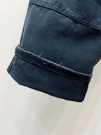 Dark blue denim pant cuffs with turned-up hem and stitched edging