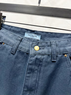 Dark blue denim waistband with brand logo tag and gold snap button