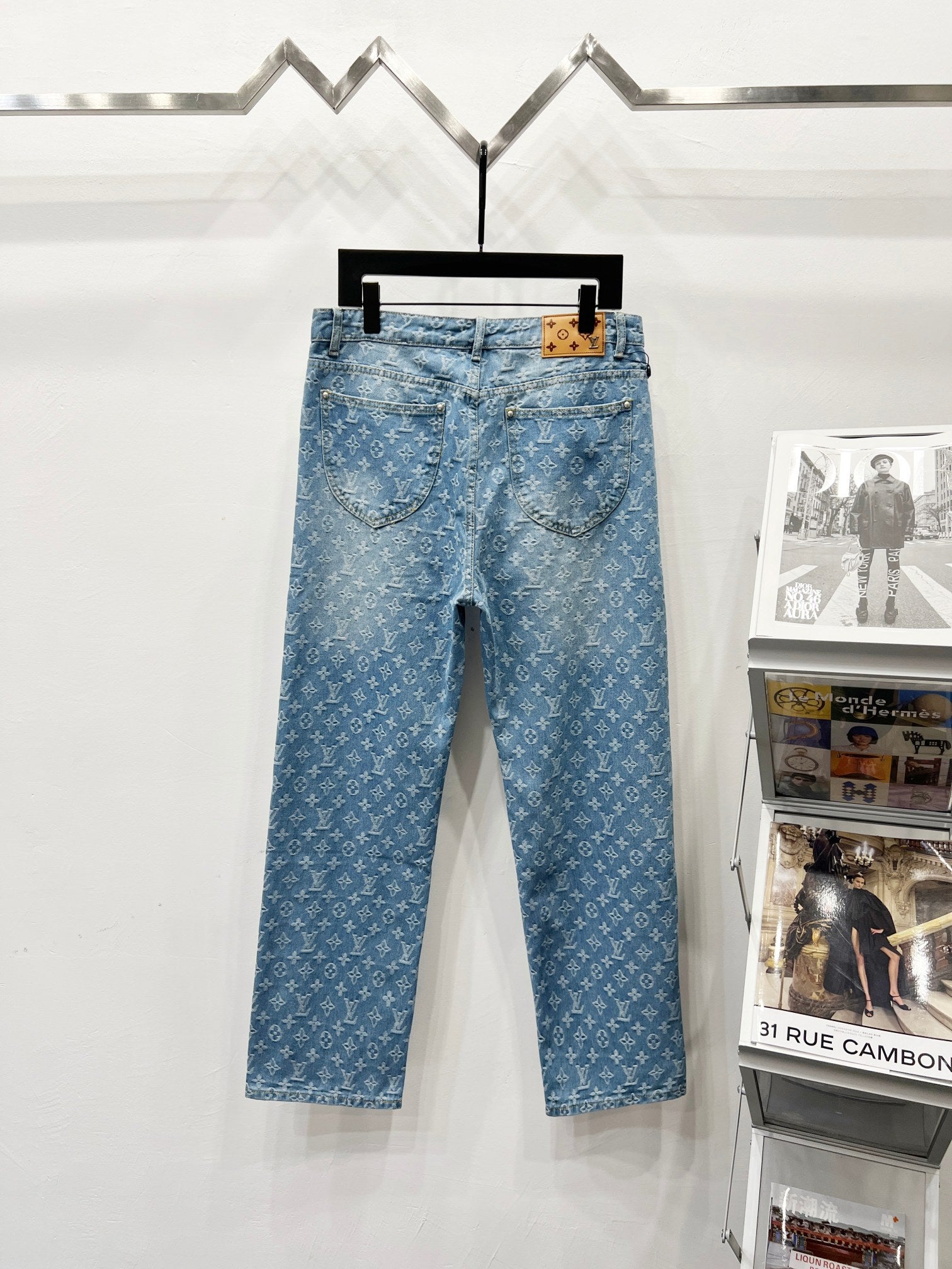 Light blue monogram denim pants with front pockets, button waist, and belt loops