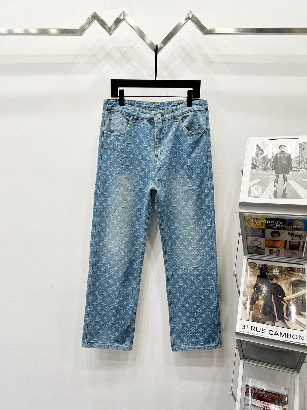 Light blue monogram denim pants with button fly and belt loops
