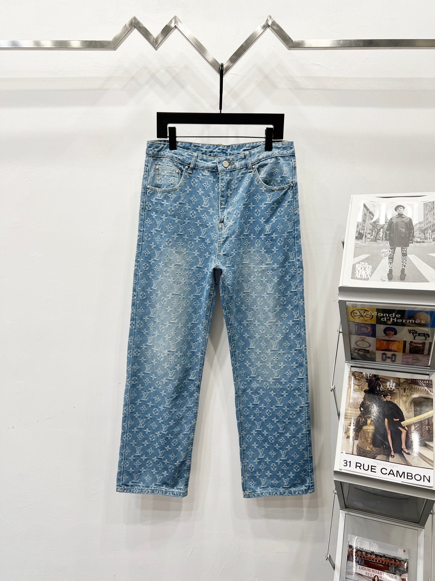 Light blue monogram denim pants with button fly and belt loops