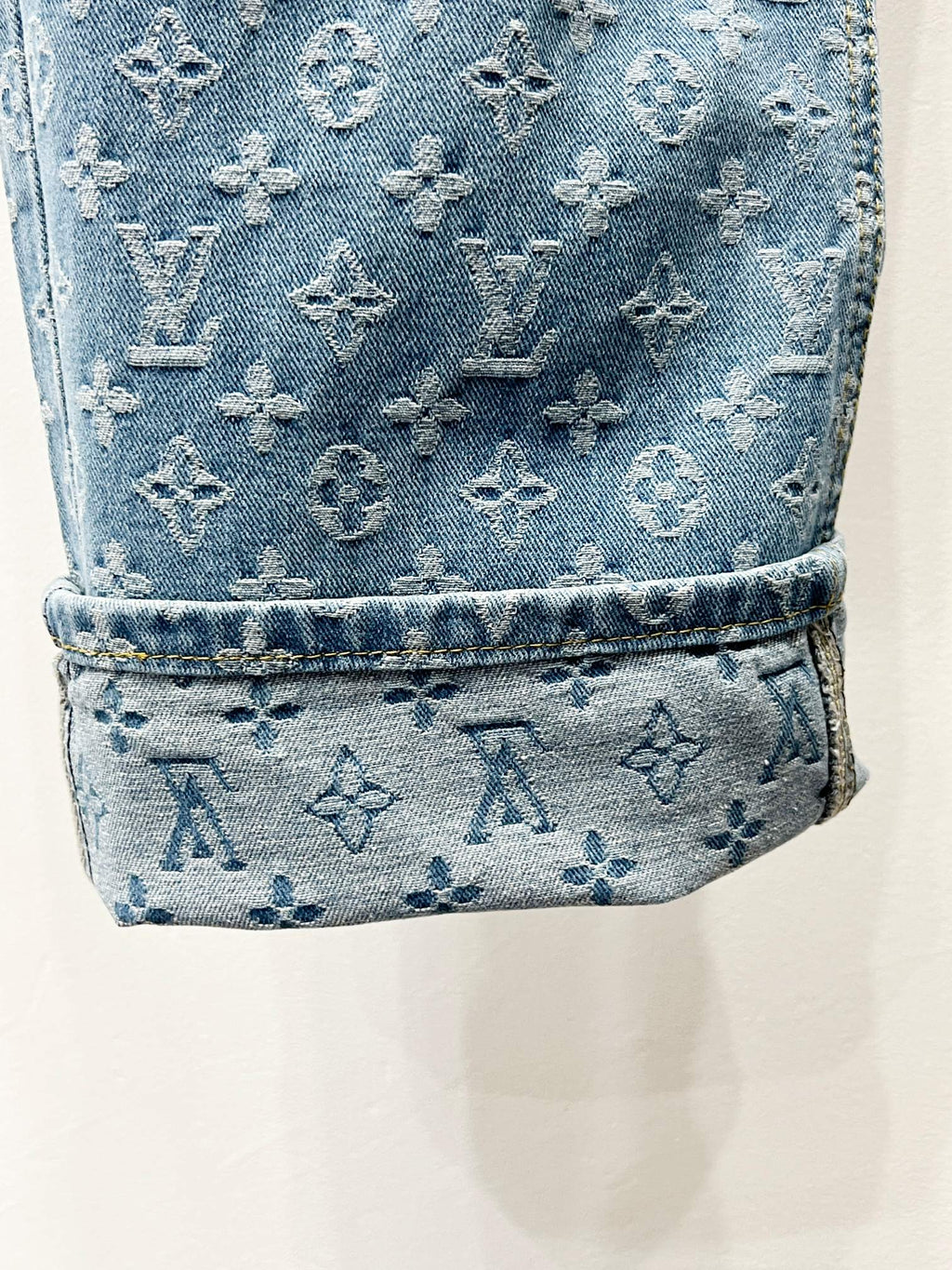 Light blue monogram denim cuff with stitched hem and textured finish