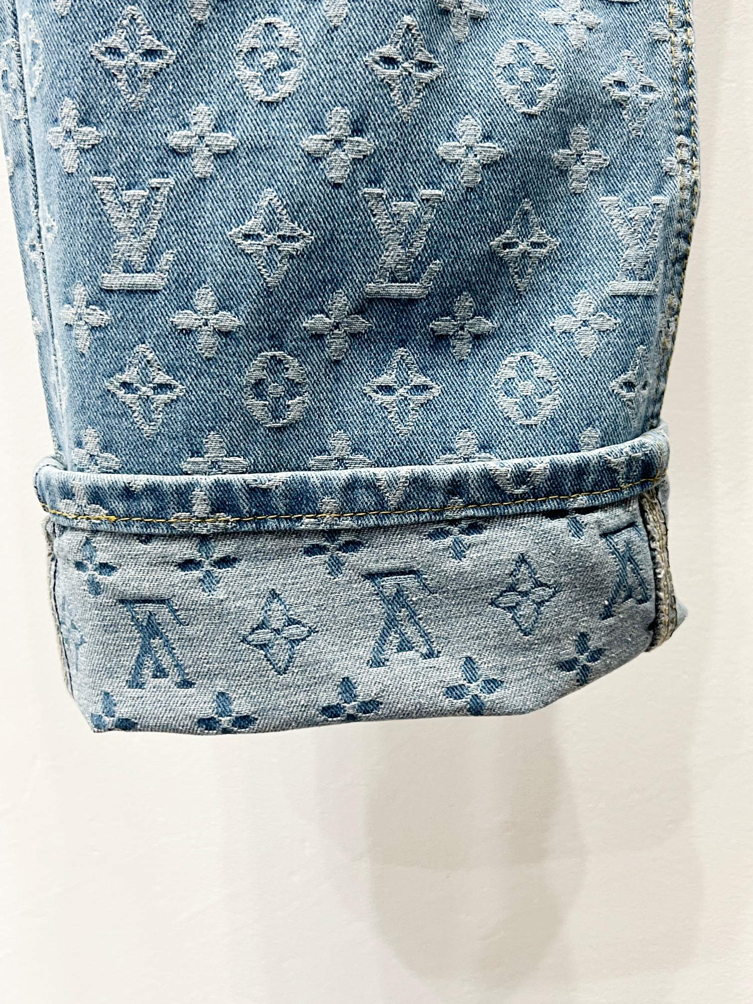 Light blue monogram denim cuff with stitched hem and textured finish