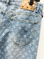 Light blue monogram denim pocket with tan patch label and gold-toned hardware