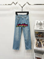 Light blue denim jeans with monogram pattern and colorful graffiti patch on front