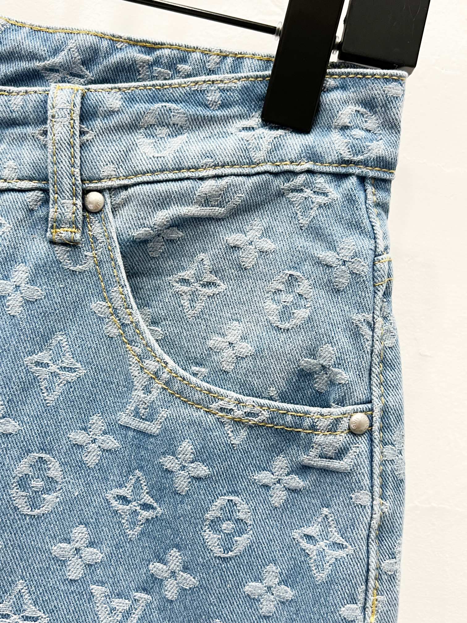 Light blue denim jeans pocket panel with monogram pattern and contrast stitching