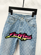 Light blue denim jeans with monogram pattern and graffiti patch on hip front