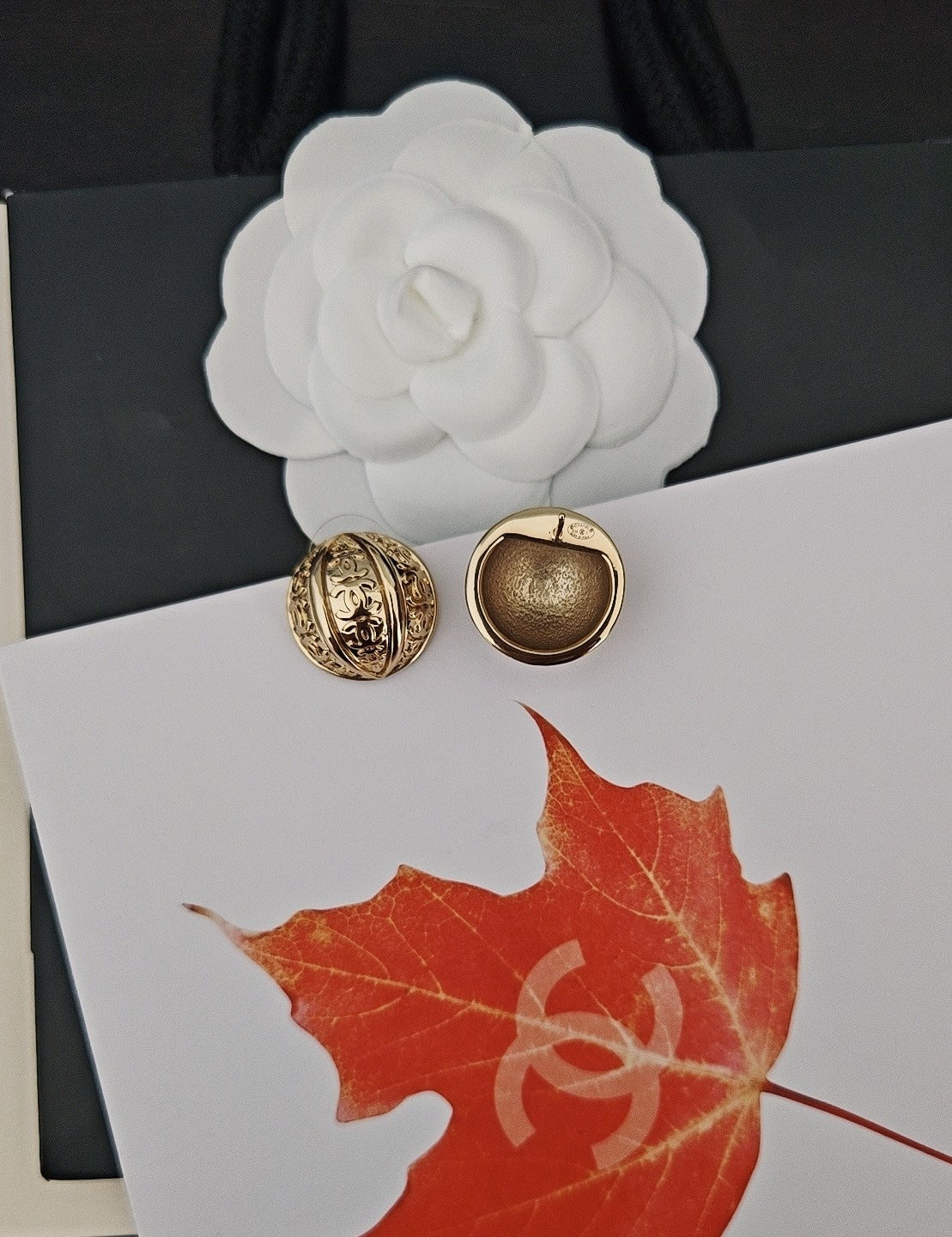 Round gold-tone stud earrings on card, one textured gold design