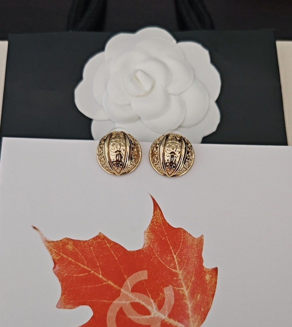 Round gold-tone stud earrings with embossed Chanel-style motifs